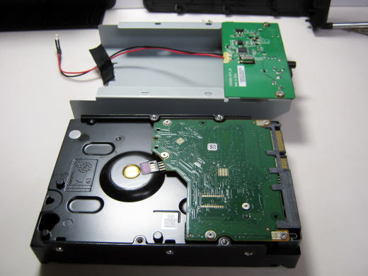 プラスネジ２本とLED配線テープを外してハードディスクを取り外します。